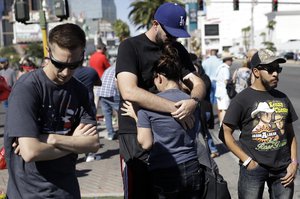 Aria James, center, is hugged by her boyfriend Reed Broschart, on the Las Vegas Strip in the aftermath of a mass shooting at a concert Monday, Oct. 2, 2017, in Las Vegas