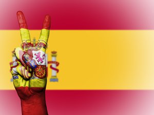 V (Victory) sign hand painted with Spanish flag over the Spain flag