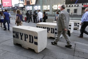 Pedestrians navigate concrete safety barriers in New York Times Square, Friday, May 19, 2017.