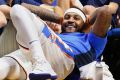 Oklahoma City Thunder forward Carmelo Anthony smiles as he watches the fourth quarter of an NBA pre-season basketball game.