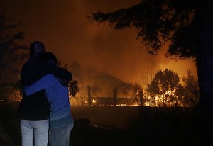 Two women hug as they watch houses burn in Santa Rosa, Calif., Monday, Oct. 9, 2017.