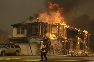 Firefighters monitor a house burning in Santa Rosa, Calif., Monday, Oct. 9, 2017.