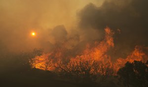 The sun rises as flames from a massive wildfire burn9 Monday, Oct. 9, 2017, east of Napa, Calif.