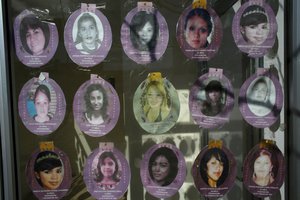 Photos of missing women are pasted in window inside a memorial park erected on the spot where eight women were found murdered and dumped in a cotton field in 2001 in Ciudad Juarez, Sunday, Jan. 17, 2016