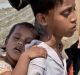 Foriza Begum holds a fan to shield her son Yosar Hossein, 7, and daughter Noyem Fatima, 2, on their way to a Bangladesh ...