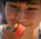 In this Tuesday, Sept. 12, 2017. photo, Amornrat Simapsaisan, a local shop manager, watches before she ate watermelon ...