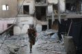 A US-backed Syrian Democratic Forces fighter runs in front of a damaged building as he crosses a street on the front ...