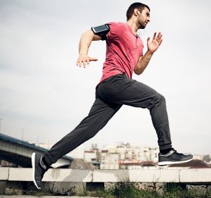 Fit man running and listening to music.