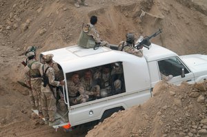 Kurdish troops known as peshmerga prepare to attack Islamic State group positions during a military operation to regain control of some villages west of the oil-rich city of Kirkuk, 180 miles (290 kilometers) north of Baghdad, Iraq, Wednesday, Sept. 30, 2015.