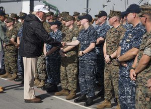 File - President Donald Trump shakes hands with Aviation Ordnanceman Airman Rebecca Vian on the flight deck of the amphibious assault ship USS Kearsarge (LHD 3) during a visit in which Trump discussed ongoing operations in Puerto Rico with senior military leaders, Caribbean Sea, 3 October, 2017.