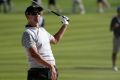 Adam Scott watches his shot from a bunker as he hits toward the 11th green during the four-ball golf matches on the ...