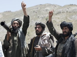 FILE - In this May 27, 2016 file photo, Taliban fighters react to a speech by their senior leader in the Shindand district of Herat province, Afghanistan.