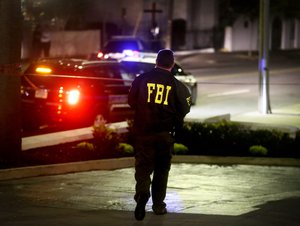 An FBI agent walks across the street from the Emanuel AME Church following a shooting Wednesday, June 17, 2015, in Charleston, S.C.