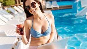 JMPCBE Cheerful young woman raising a bottle of soda