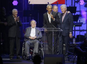 Former President Barack Obama, speaks as fellow former Presidents, from left, Jimmy Carter, George H.W. Bush,  George W. Bush, and Bill Clinton look on during a hurricanes relief concert in College Station, Texas