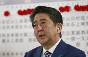 Japanese Prime Minister Shinzo Abe, leader of the Liberal Democratic Party, answers a question from reporter during a TV interview on the ballot counting of the parliamentary lower house election at the party headquarters in Tokyo, Sunday, Oct. 22, 2017.