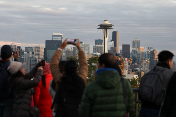 Tourists take photos of the Seattle view from Kerry Park.