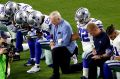 The Dallas Cowboys, led by owner Jerry Jones, take a knee before an NFL football game against Arizona.