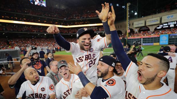 Party time: Jose Altuve is chaired off the field by teammates after Houston defeated the Yankees in game seven last week.