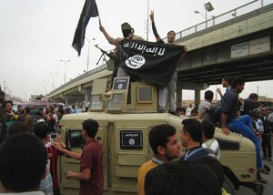 In this Sunday, March 30, 2014, file photo, Islamic State group militants hold up their flag as they patrol in a commandeered Iraqi military vehicle in Fallujah, 40 miles (65 kilometers) west of Baghdad, Iraq. Abu Bakr al-Baghdadi’s forces swept into Ramadi and Fallujah in Iraq's Anbar province.