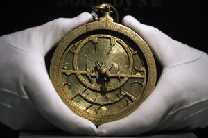 A Sotheby's employee holds an Astrolabe dated back to 1020 AD as part of the Middle Eastern Art auction at the auction house Sotheby's in London, Friday, April 21, 2017.