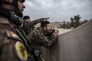 Iraqi members of the Special Forces scan the area held by Islamic state militants from a roof in Mishraq district in Mosul, Iraq, Tuesday, Dec. 20, 2016.