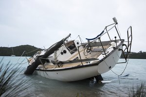 A sailboat lies on the shores of Ferry Reach after breaking free from its mooring during Hurricane Nicole in St. Georges, Bermuda, Thursday, Oct. 13, 2016.