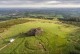 Aerial view of the passage tombs during the 2016 excavation of the larger tomb (SMR No. DU025-001001). The smaller one (SMR No. DU025-001002) is marked ordnance pillar. Image courtesy of Abarta Heritage.