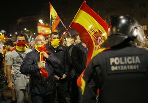 Holding Spanish flags, demonstrators confront Catalan police as they are prevented from moving forward during a march against the unilateral declaration of independence approved earlier by the Catalan parliament in downtown Barcelona Friday, Oct. 27, 2017.