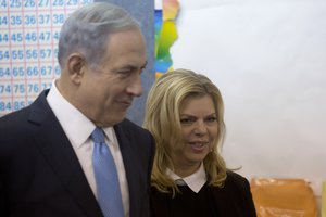 Israeli Prime Minister Benjamin Netanyahu stands with his wife Sara after voting in Israel's parliamentary elections in Jerusalem