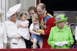 Britain's Queen Elizabeth II, right, with Prince William holding Prince George, centre, and Kate, Duchess of Cambridge holding Princess Charlotte, left, on the balcony during the Trooping The Colour parade at Buckingham Palace, in London, Saturday, June 11, 2016. Hundreds of soldiers in ceremonial dress have marched in London in the annual Trooping the Colour parade to mark the official birthday of Queen Elizabeth II. The Trooping the Colour tradition originates from preparations for battle, when flags were carried or