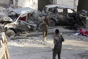 Somali soldiers stand near the wreckage of vehicles in Mogadishu, Somalia, Sunday, Oct 29, 2017, after a car bomb detonated Saturday night.