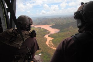 Agents peer out from an open door as they scan the wet landscape below for survivors of Hurricane Maria during a flyover of Puerto Rico in a U.S. Customs and Border Protection, Air and Marine Operations, Black Hawk September 23, 2017. U.S