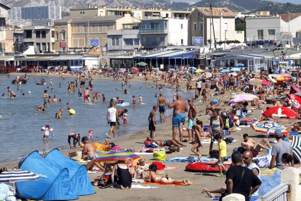 People bathe at the Pointe Rouge beach in Marseille, southern France.