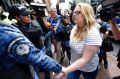 Cassandra Sainsbury is escorted by police to a court hearing in Bogota, Colombia.