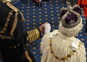 Britain's Queen Elizabeth II wearing the Imperial State Crown, holds the hand of Prince Philip