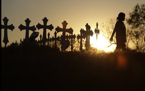 Miranda Hernandez pays her respects as she visits a makeshift memorial with crosses placed near the scene of a shooting at the First Baptist Church of Sutherland Springs, Monday, Nov. 6, 2017, in Sutherland Springs, Texas.