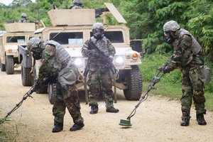 File - Soldiers use metal detectors while searching for possible explosives during a chemical, biological, radiological, nuclear, and explosive scenario part of a Patriot missile system certification training exercise at Kadena Air Base in Japan, Oct. 17, 2017.