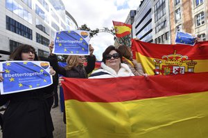 Anti Catalonia independence demonstrators hold Spanish flags during a protest coinciding with the arrival of the Catalan mayors who travelled to Brussels to take part in an event in support of the ousted Catalan government on Tuesday, Nov. 7, 2017.