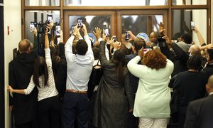 People rush the doors of the jury assembly room as former President Barack Obama departs after being dismissed from jury duty in the Daley Center on Wednesday, Nov. 8, 2017, in Chicago. For his time served, Obama is in line to be paid $17.20. (AP Photo/Charles Rex Arbogast)