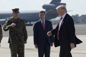 File - President Donald Trump passes Joint Chiefs Chairman Gen. Joseph Dunford, left, and National Security Adviser Michael Flynn as he arrives via Air Force One at MacDill Air Force Base in Tampa, Fla., Monday, Feb. 6, 2017.