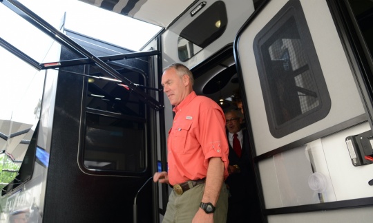 Secretary Zinke in casual clothes stepping out of a large RV.