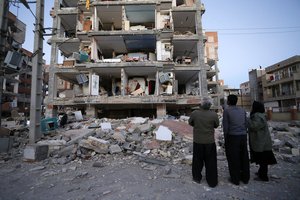 In this photo provided by the Iranian Students News Agency, ISNA, people look at destroyed buildings after an earthquake at the city of Sarpol-e-Zahab in western Iran, Monday, Nov. 13, 2017.