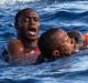 Migrants from a sinking inflatable dinghy board a Libyan coast guard ship during a rescue operation at sea in ...