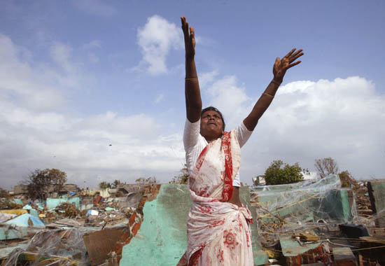 A woman gesturing to relief workers arriving to help villagers recover from a deadly Indian Ocean tsunami, Nagappattinam, Tamil Nadu, India, December 31, 2004. 