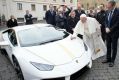 Pope Francis writes on the bonnet of a Lamborghini donated to him by the luxury sports car maker,.