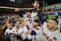 Party time: Jose Altuve is chaired off the field by teammates after Houston defeated the Yankees in game seven last week.