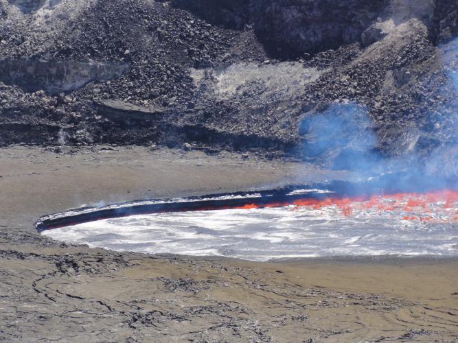 Gas in the lava lake was rapidly released during the 10:20 am explosive event, causing the lava lake surface to drop a few meters (yards).  This photo was taken moments after the explosive event, and shows the overhanging ledge of lava along the rim that was exposed as the lava level dropped.   