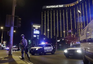 Police officers stand along the Las Vegas Strip the Mandalay Bay resort and casino during a shooting near the casino, Sunday, Oct. 1, 2017, in Las Vegas.