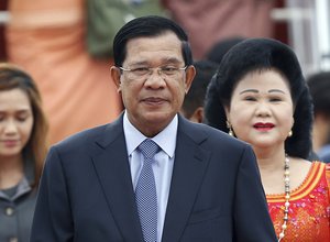 File - In this Nov. 20, 2015 file photo, Cambodia's Prime Minister Hun Sen and his wife Bun Rany arrive for the 27th Association of Southeast Asian Nations (ASEAN) summit, in Sepang, Malaysia.  During a meeting between the Information Ministry and journalists Thursday, all media must use his full, honorary, six-word title —